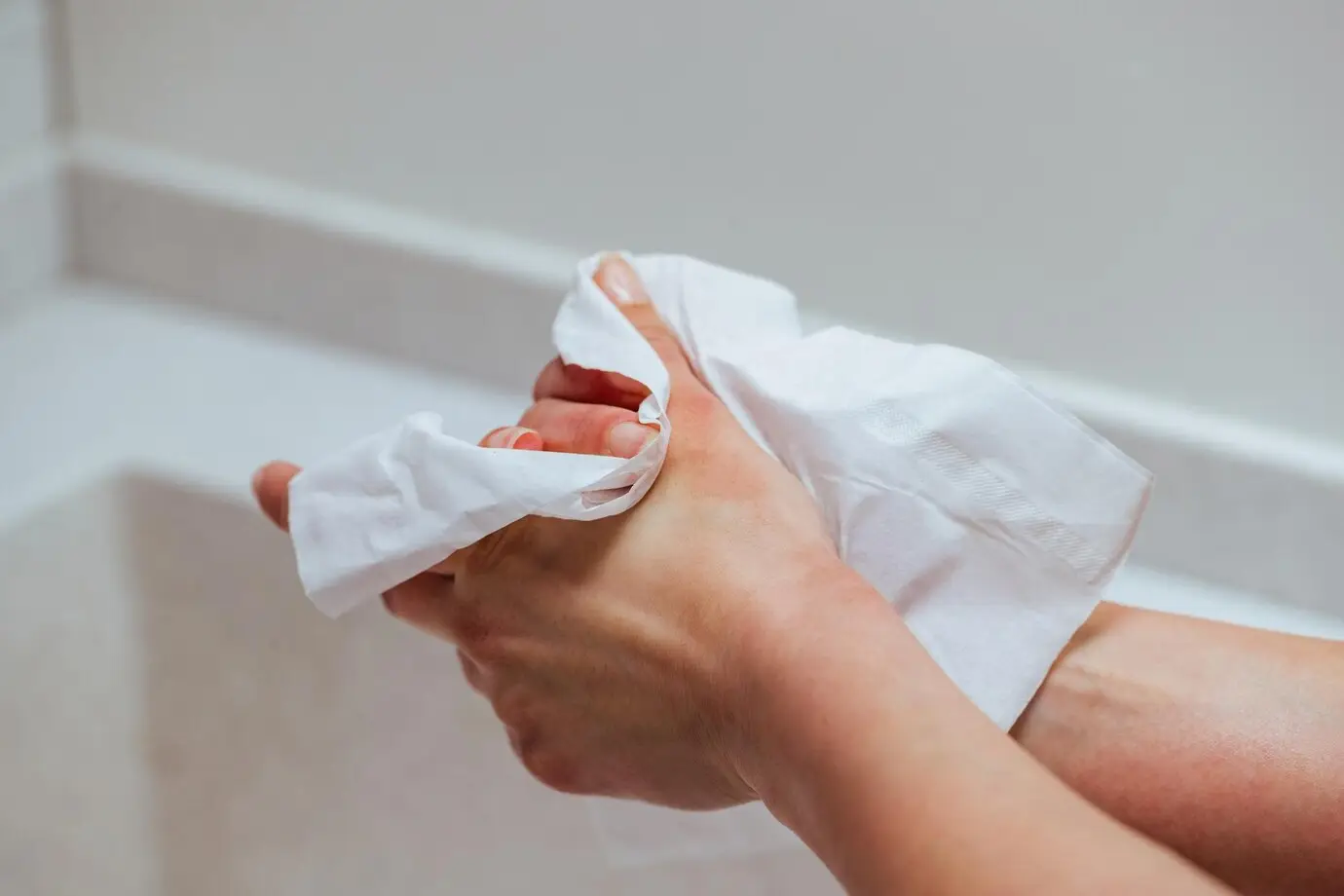 closeup-woman-using-antibacterial-wipe-cleaning-hands-bathroom_637285-4741